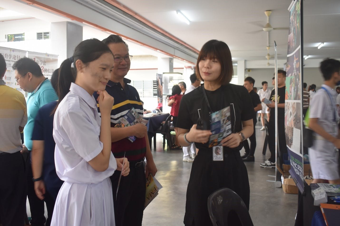 家长与学生在技职教育展柜台询问相关资讯