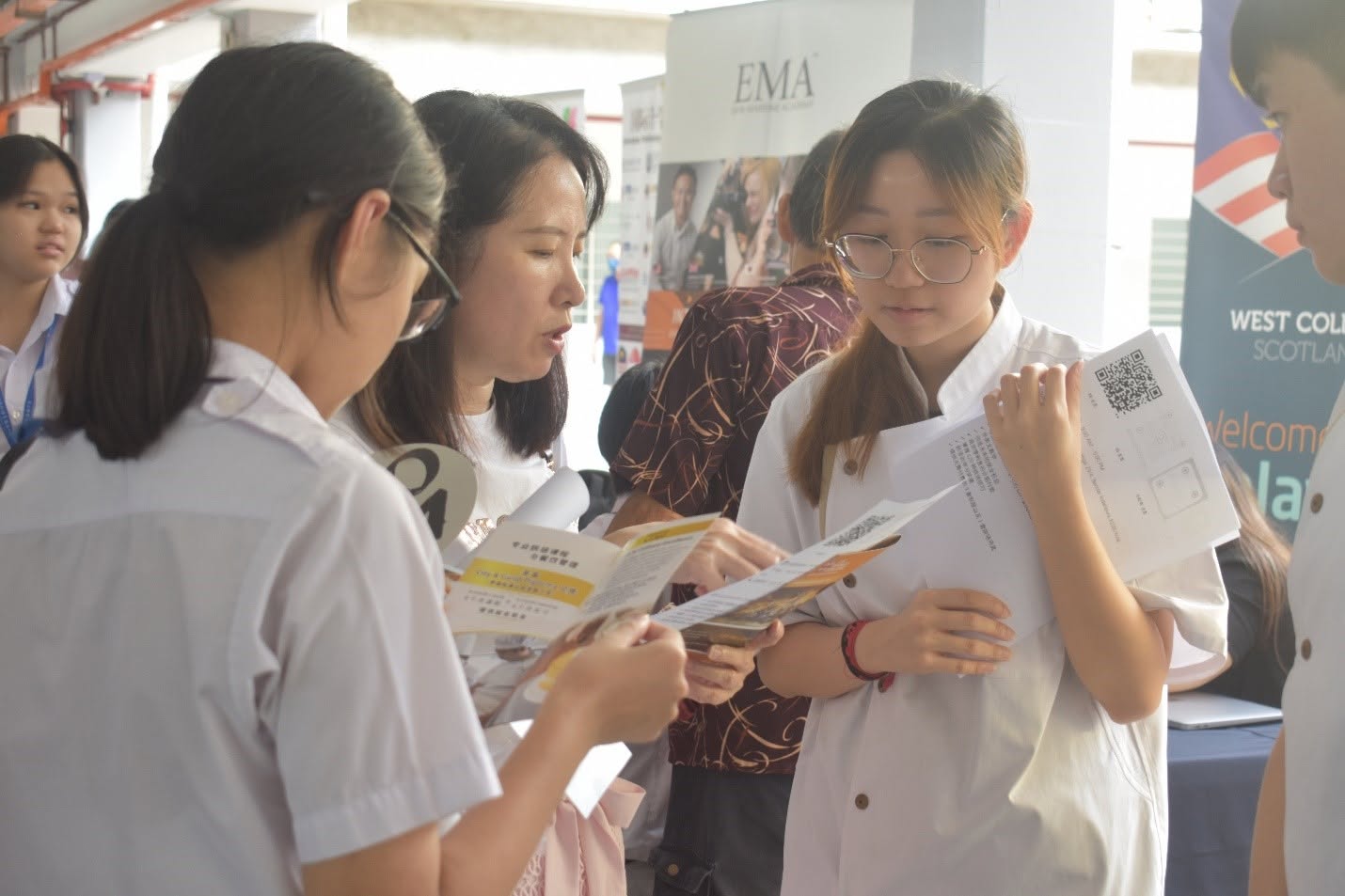家长与学生在技职教育展柜台询问相关资讯