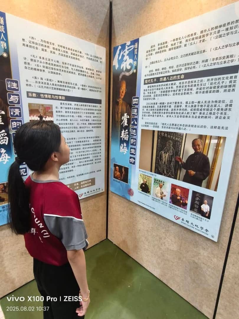 观览儒家展的学生细心投入地消化儒家展看板上的儒家历史代表人物史迹。