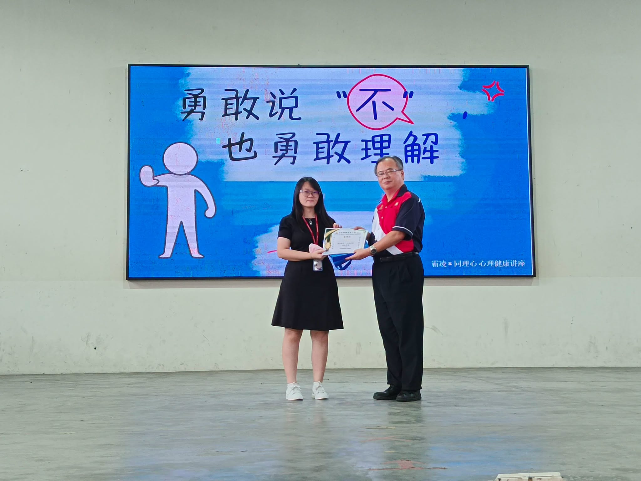 北干那那育民二校丘玖南校长颁发感谢状予培群独中辅导处罗洁颖老师。