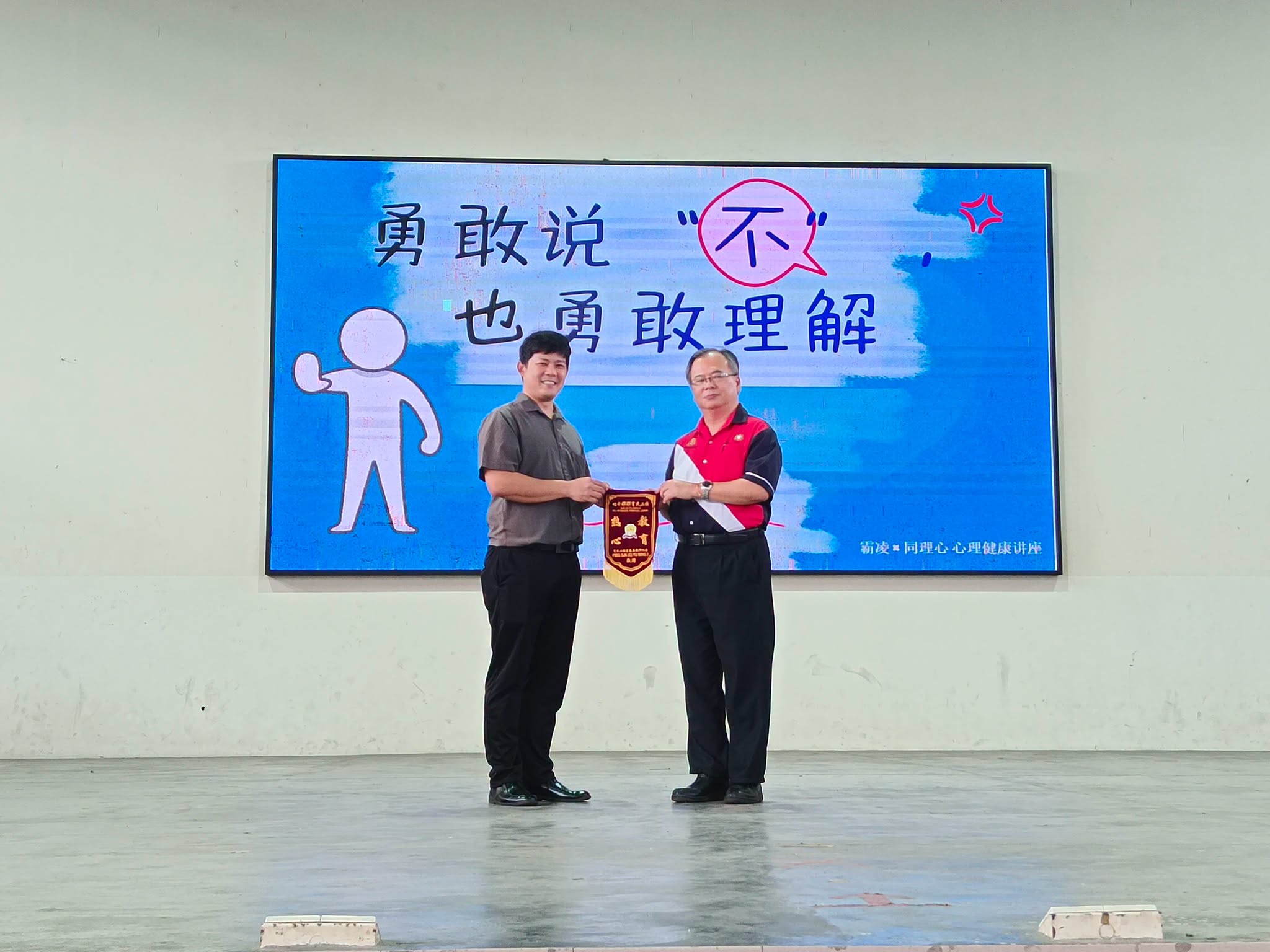 北干那那育民二校丘玖南校长颁发锦旗及感谢状予培群独中辅导处关振顺主任。