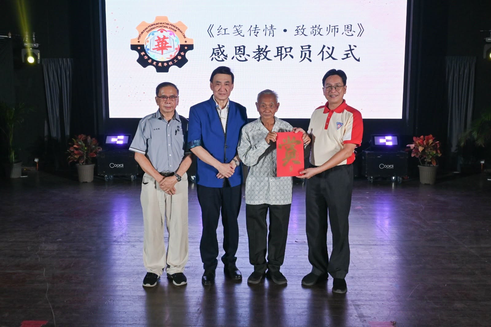 笨珍县发展华校工委会财政郑国平代表该会致赠红包予培群独中全体教职员，由王楨文校长代表接领，表达对教师长期付出的肯定与敬意。